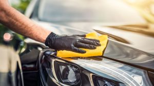 Person applying wax to car's paintwork