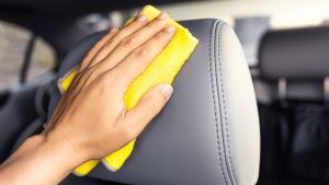 Person applying conditioner to car's leather seats