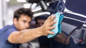 Person applying wax to car's paintwork